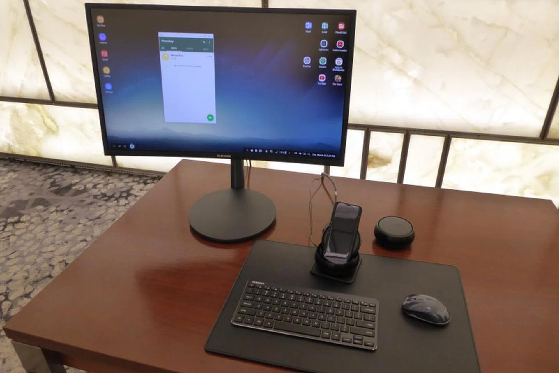 A complete Samsung DeX setup with a Galaxy S8 powering an Android desktop setting with monitor, keyboard and mouse.