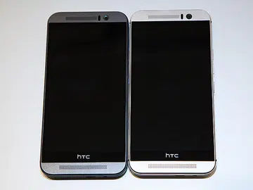 The new HTC One M9 comes in three different colors. Shown here is the gunmetal grey version (on the left) and the two-tone gold on silver design (on the right).