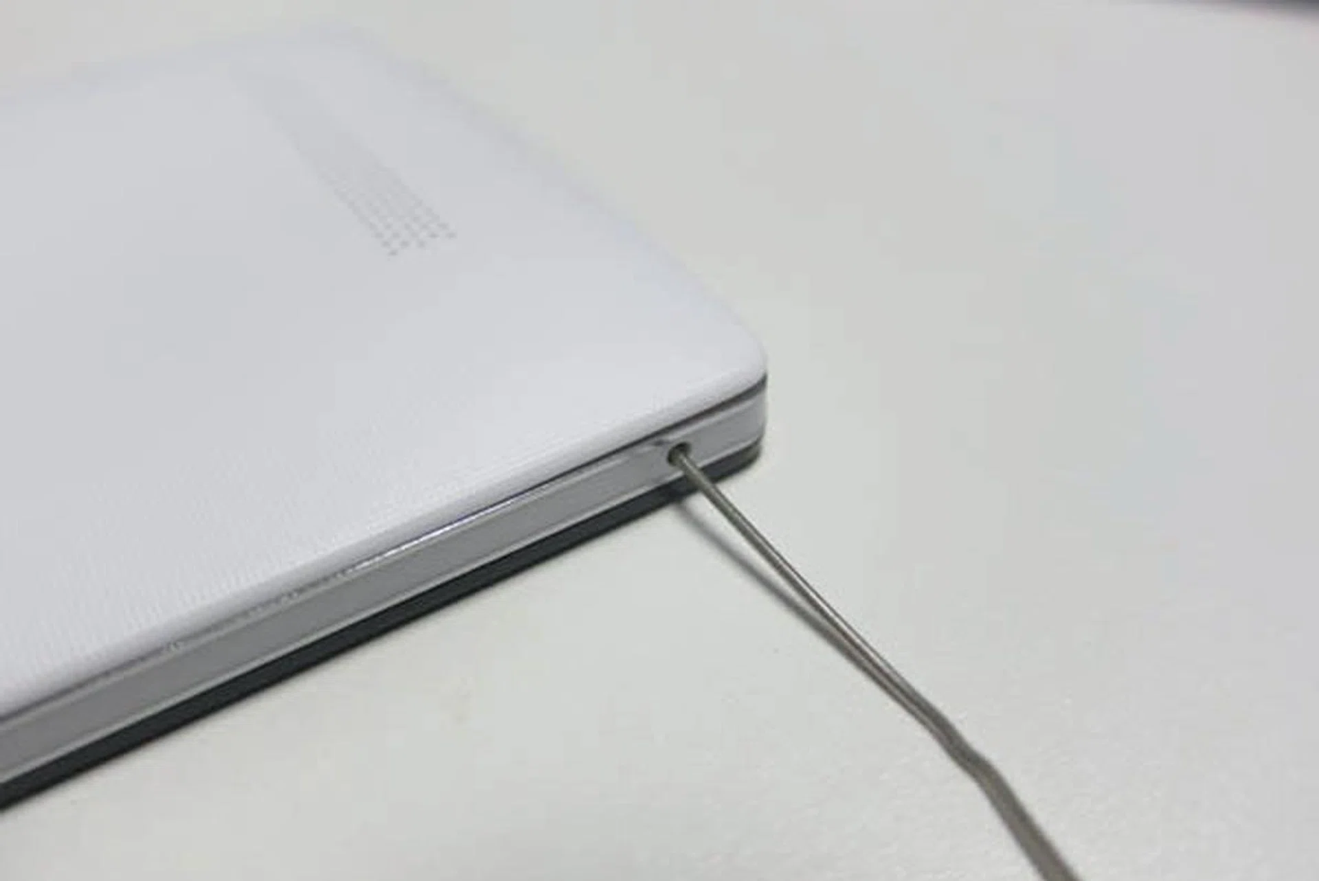 Using a pin to dislodge the back cover - very cumbersome.