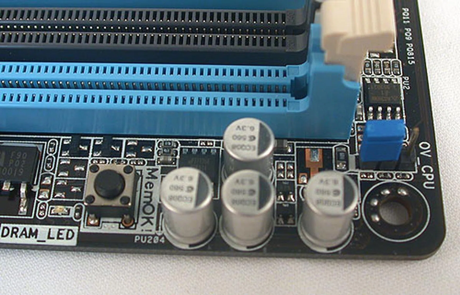 The MemOK! feature can be activated by pressing the button, for those occasions when your memory modules/timings are the cause for bootup failure. On the right, there's another blue jumper to increase the maximum voltage selectable for the CPU from the BIOS.