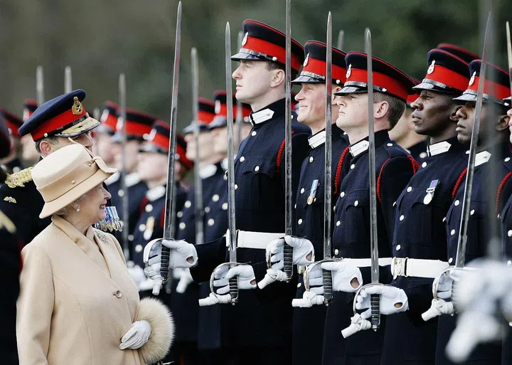 Queen Elizabeth II smiles at Prince Harry, 21, as she inspects soldiers at their passing-out Sovereign's Parade at Sandhurst.