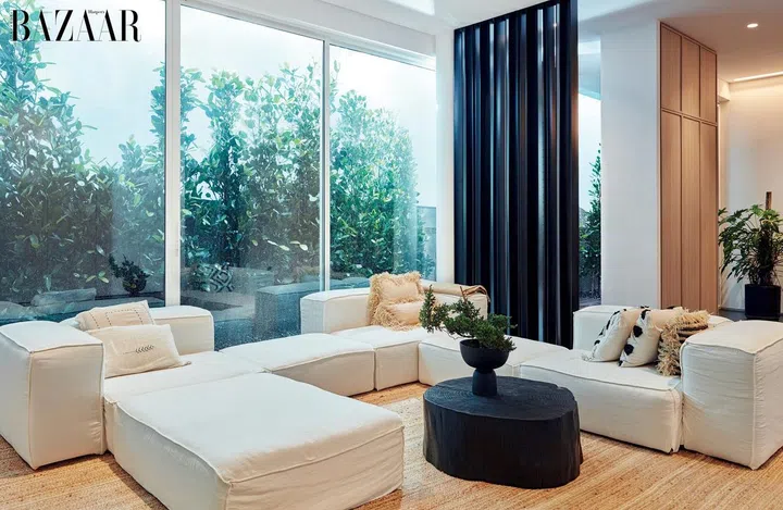 The living room has a large communal sofa and a torched wood coffee table.
Photo: Gan