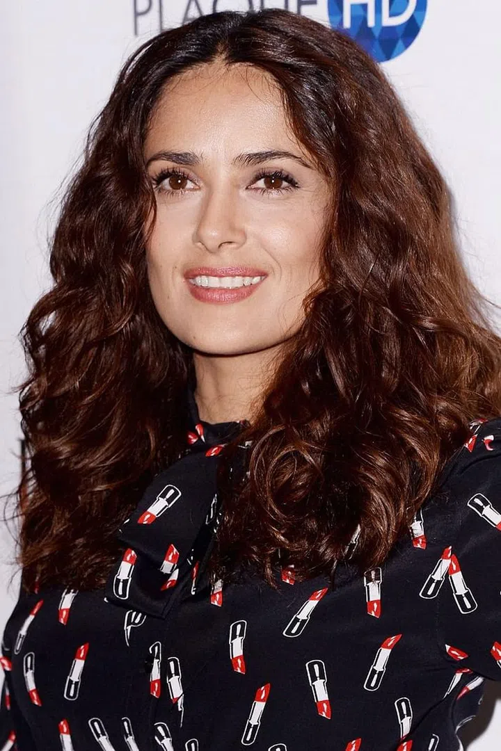 Thick, curly hair lends itself to flyaways - and Hayek shows how pretty it is when you don't fight 'em. Photo: Getty