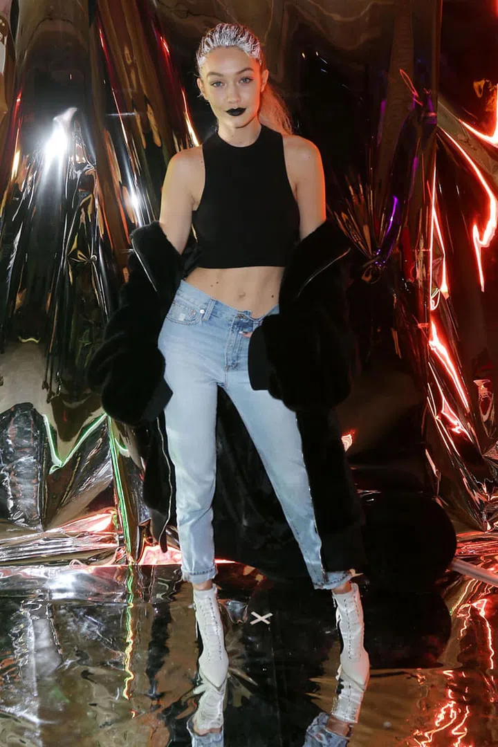 Still in her post-show hair and makeup for Rihanna's Fenty x Puma show, Hadid rocks her bold beauty look in an oversized faux fur zip-up hoodie, jeans and a crop top with lace-up booties at a Maybelline New York Fashion Week party. Photo: Getty