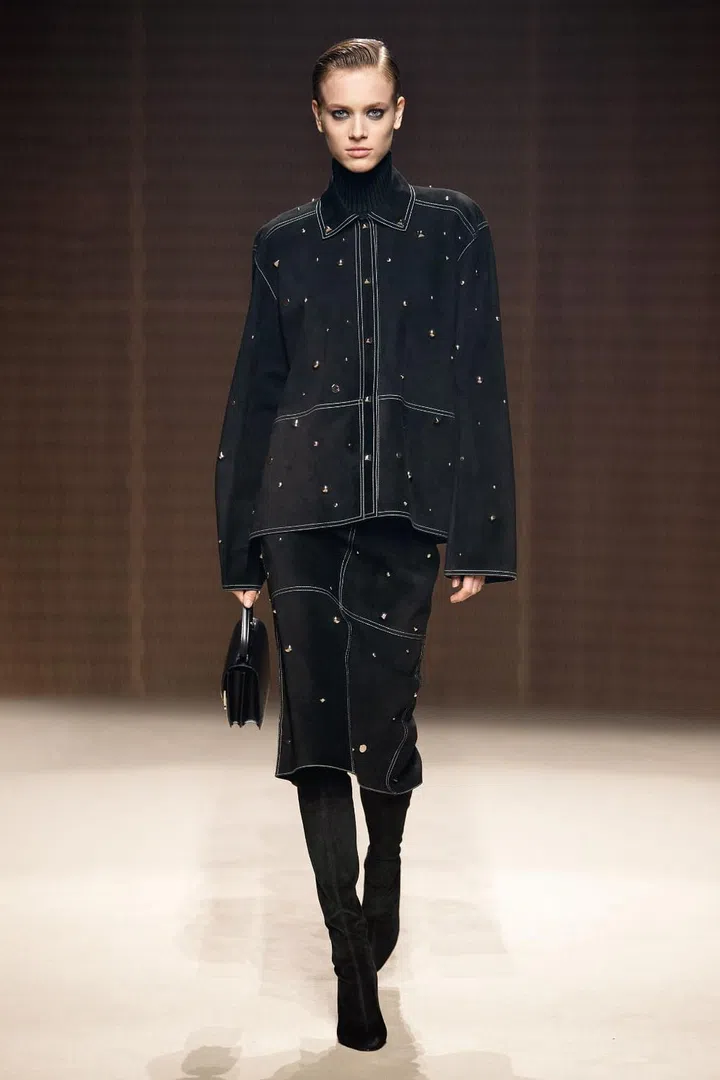 The classical, haute bourgeois look may
have been a running trend this season, but it has always been Hermès’ calling card. For fall/winter 2019, Nadège Vanhee-Cybulski proposed slim, body-skimming (but not constricting) silhouettes that hit right below the knee, worn over knee-high boots with just the right amount of slouch. It was a modern update on the Belle de Jour aesthetic—polished and buttoned-up on the surface but with an undercurrent of sensuality, reinforced by the abundance of black leather in the collection. Given that the Maison’s savoir-faire with leatherwork is unparalleled, the leather pieces were particularly strong—whether they were the pencil skirts paired with printed silk
blouses, the leather shorts adding a youthful flair or the full leather suits that managed to be both rigorous and sensual. Outerwear was also a highlight, with minimal shapes made texturally and visually rich with surface effects and the addition of oversized pockets and D-ring belts.
