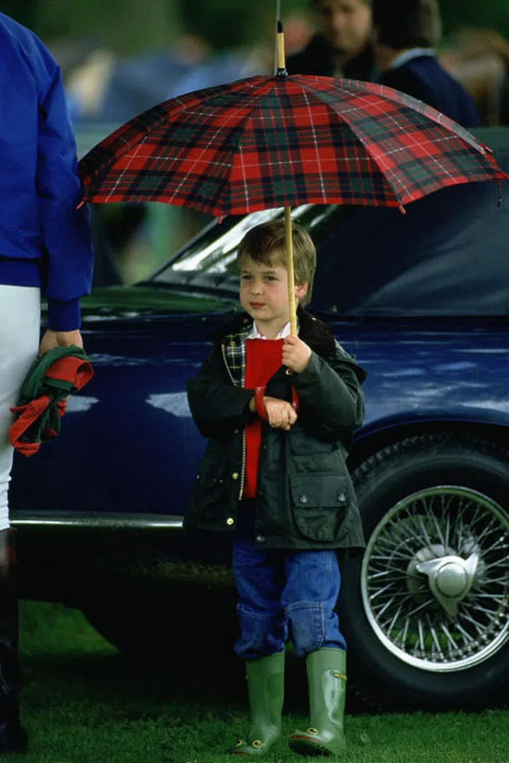 From a young age, Prince William knew that a plaid umbrella was the perfect accessory for a pair of Wellies and a Barbour jacket.