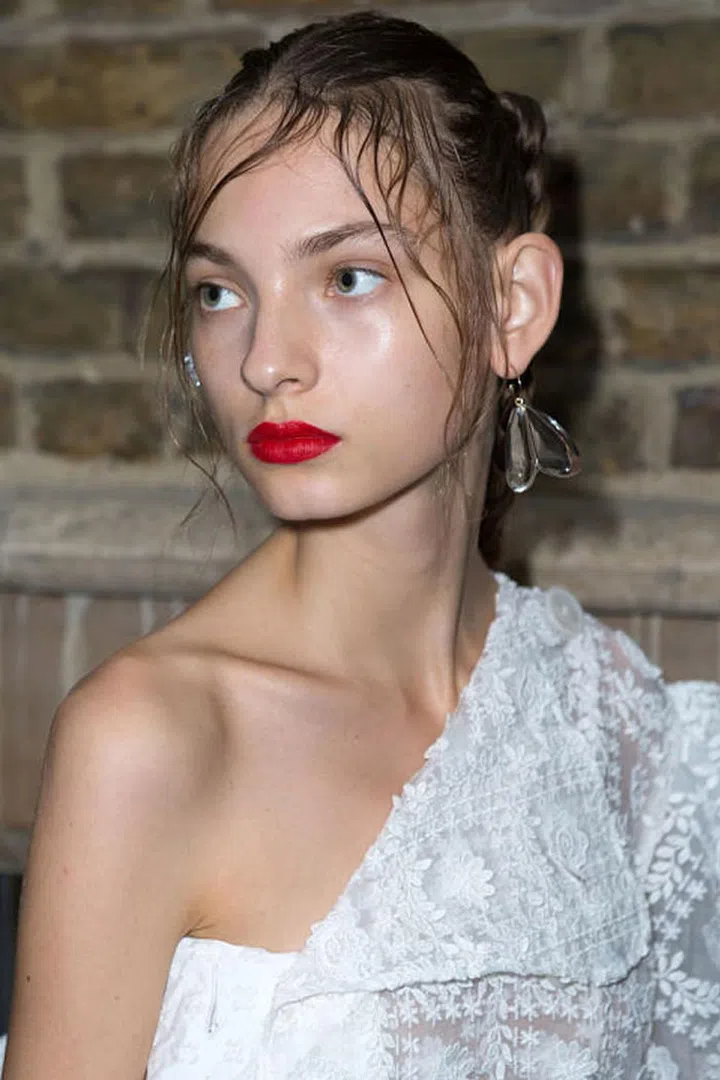The same raw skin and red lip combination could be see backstage at Simone Rocha.