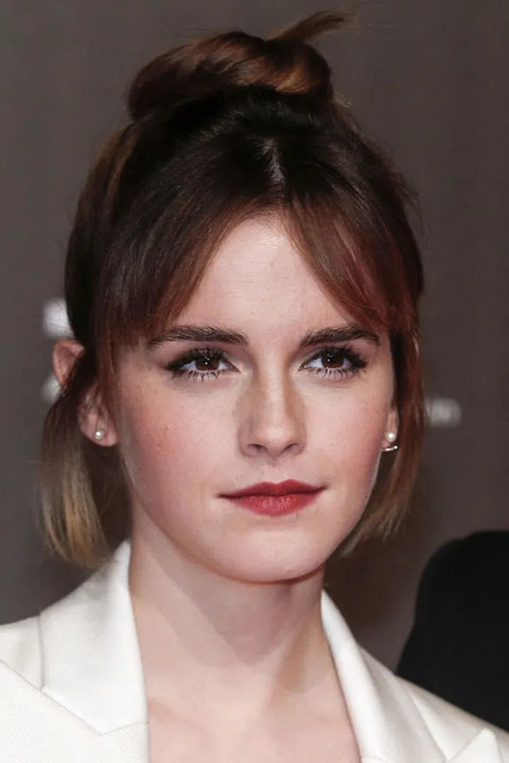 A topknot framed by split bangs and tendrils.