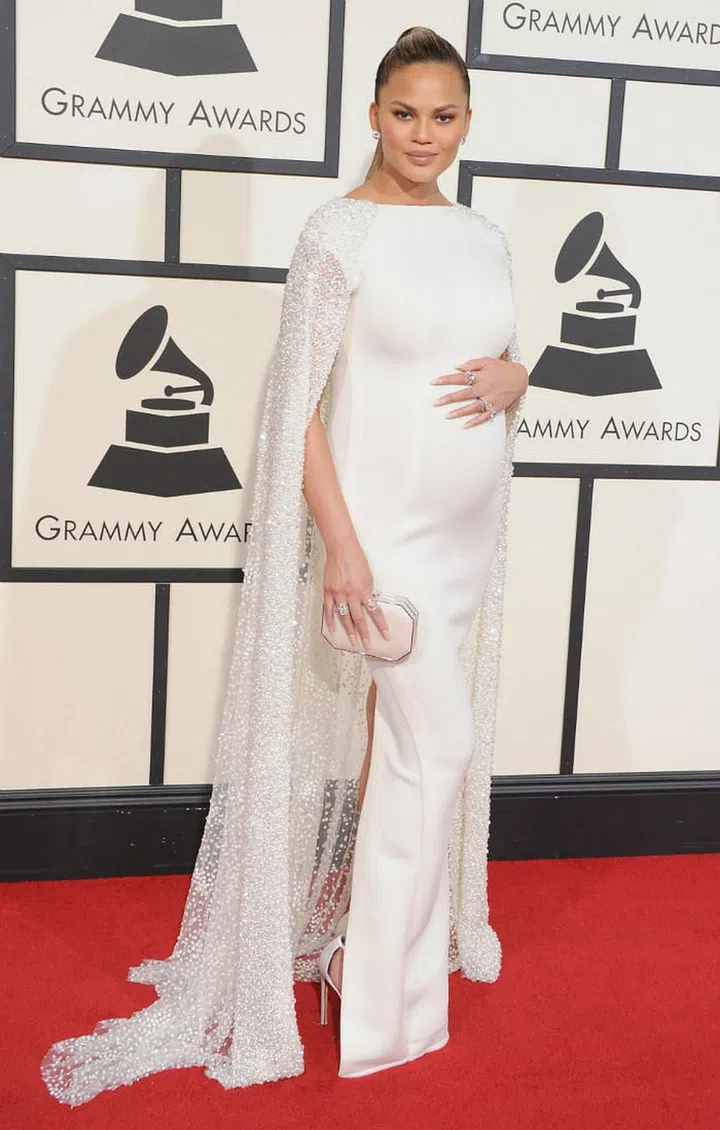 Chrissy boasts her growing baby bump and glowing skin in this caped Zuhair Murad design. Photo: Getty