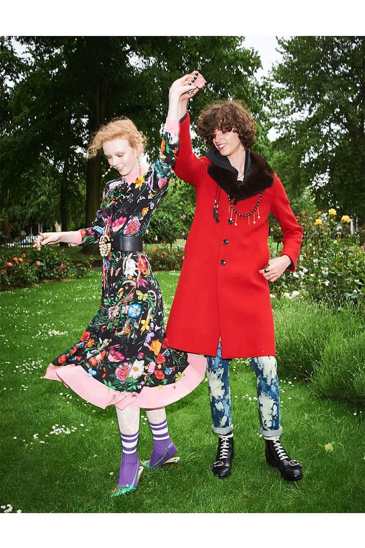 (On her) Silk dress; metal 
earrings; metal rings; leather 
belt with metal buckle; lace 
stockings; knit socks; leather slingback 
pumps. (On him) Wool and fur coat; denim jeans; metal necklace; bead and metal necklace; metal rings; leather boots, Gucci.
