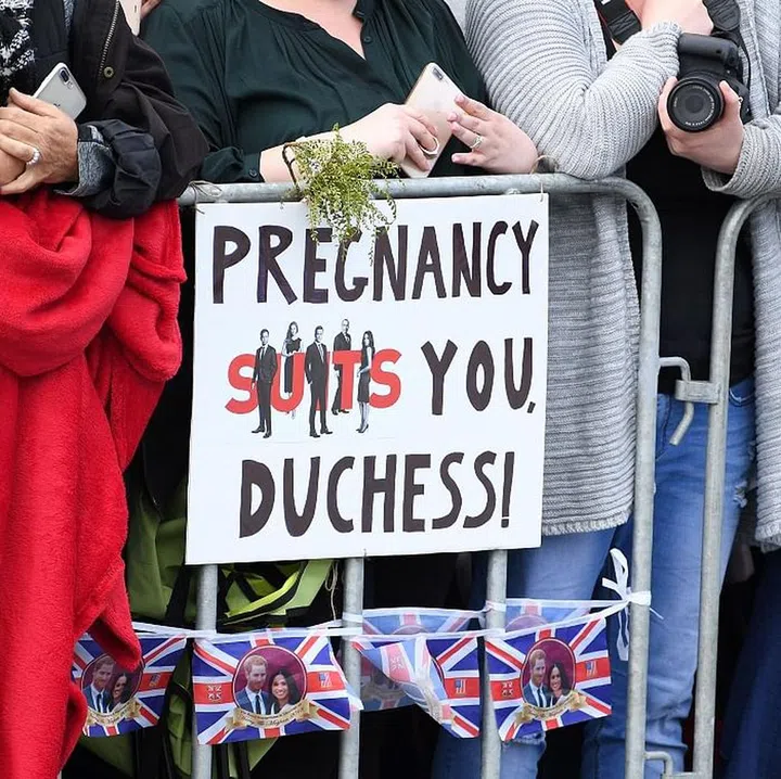 Fans excitedly hold signs for Meghan and Harry. Photo: Getty 