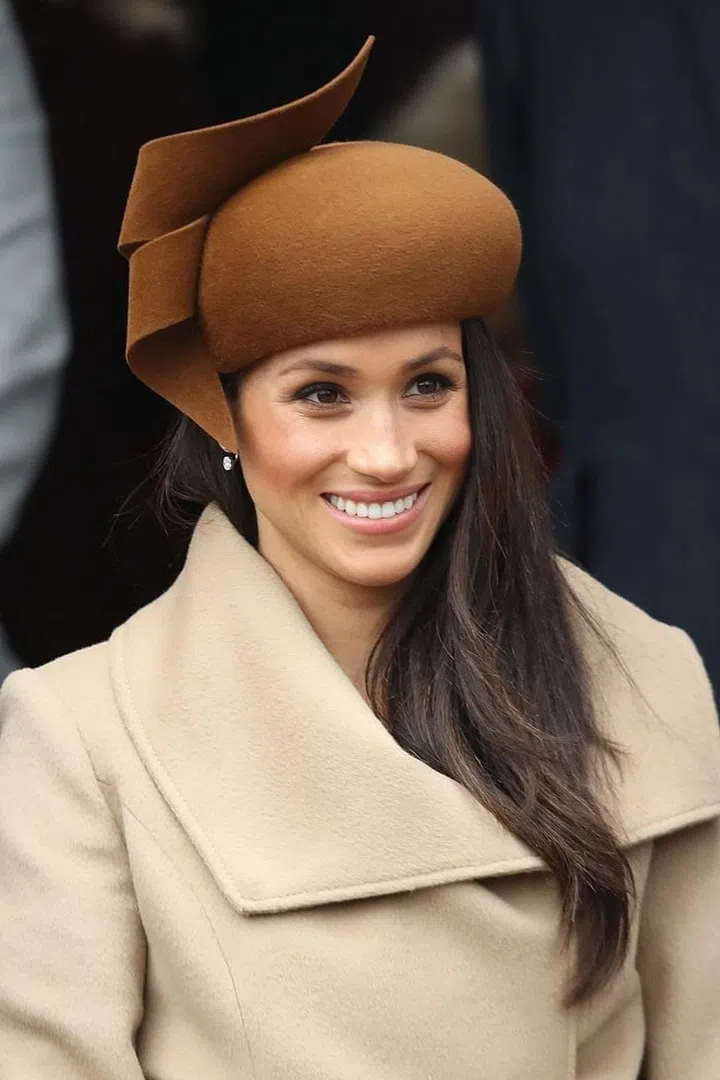 Meghan Markle wore her hair swept to one side, and paired her sculptural hat with diamond Birks earrings. Photo: Getty 