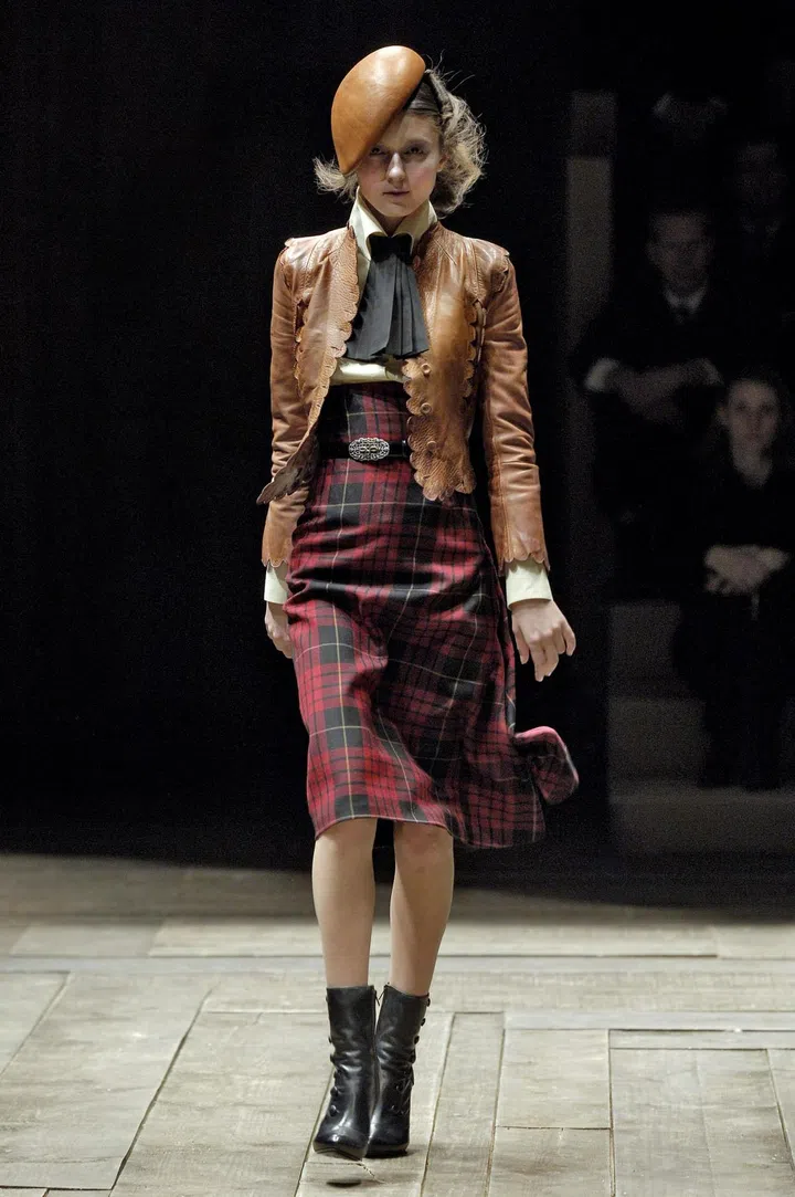 A high-waisted skirt with asymmetric draping in red and black wool tartan, from the Alexander McQueen Autumn/Winter 2006 collection. Credit: Chris Moore/Catwalking.com