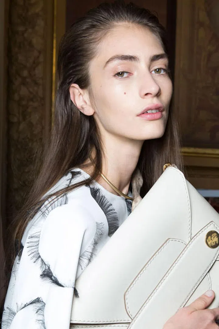 The Look: Sporty '80s
How-To:  There was a simplicity to the beauty look at Stella McCartney. But don't mistake this for no-makeup makeup. There was makeup used here, but it was to make the girls seem fresh and sporty. "It's a nod to the '80s but that kind of sporty '80s feel," said makeup artist Pat McGrath backstage. "You see that in the hair and partly in the clothing." McGrath groomed the skin with moisturizer and foundation, filled-in and brushed through the brows, and then added a bit of glow along the cheekbones. Hairstylist Eugene Souleiman pushed the hair back off the face but in a softer, fluffier way than we've seen at other shows; it wasn't shellacked or covered in gel. That way, when the models stepped out at the end of the show to perform their choreographed dance number (yes, that really happened), their faces glowed and their hair bounced with ease. 