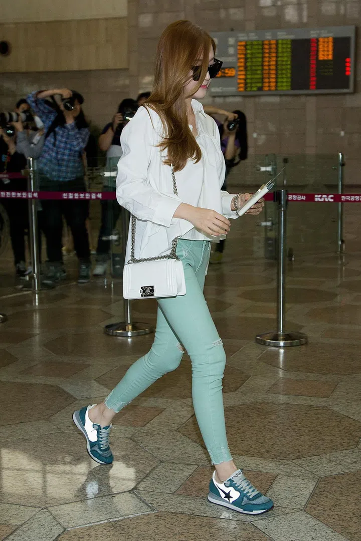 Spotted at Gimpo Airport in Seoul, Jung sports mint green skinny jeans with a semi-sheer white windbreaker and Chanel purse for a feminine take on athleisure. 
Photo: Getty