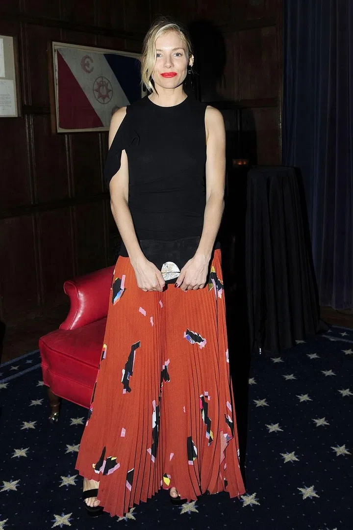 Sienna Miller is going back to her boho roots in a printed, pleated maxi skirt and architectural top. Photo: Getty 