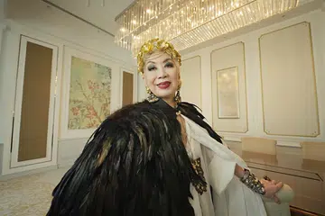 Harper’s Bazaar Singapore 25th Anniversary Where Fashion Live | Genevieve Peggy Jeffs in a custom feathered cape, gold headdress and pearl jewellery