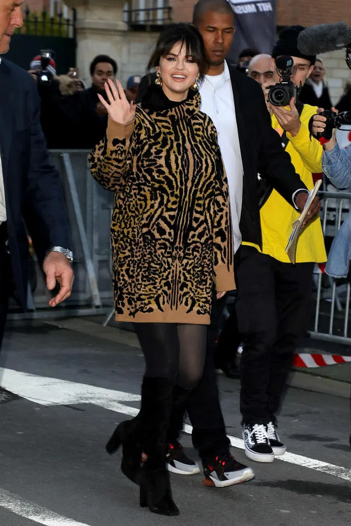 Selena Gomez wears a cheetah print turtleneck by Givenchy, gold earrings with black tights and suede knee-high boots from Saint Laurent in Paris, France.

Photo: Pierre Suu/Getty