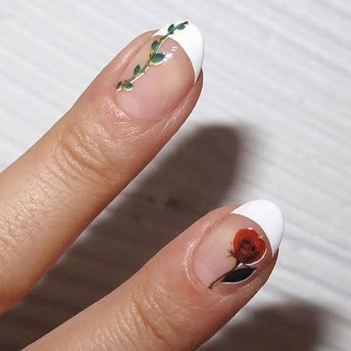 An easy addition to the french tip are with decals. After creating the traditional look, layer a thin coat of clear top coat. While tacky, gingerly set your design and press down. Finish with a topcoat to secure. 
Design by nataliepavloskinails