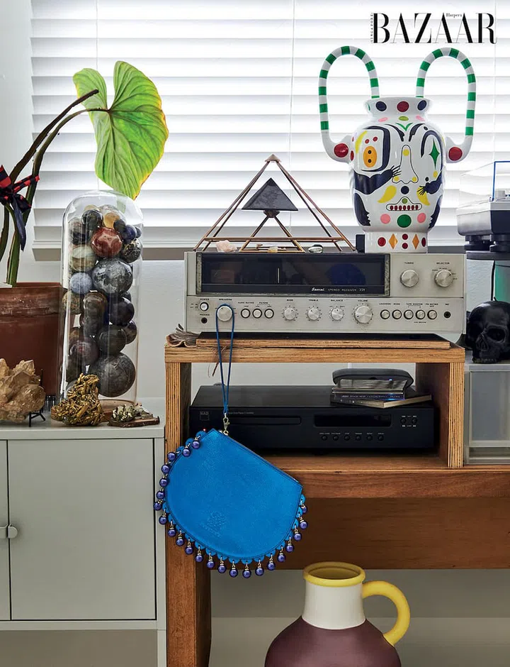 A Jaime Hayon vase sits by the window alongside an electric blue Kanyeka clutch.