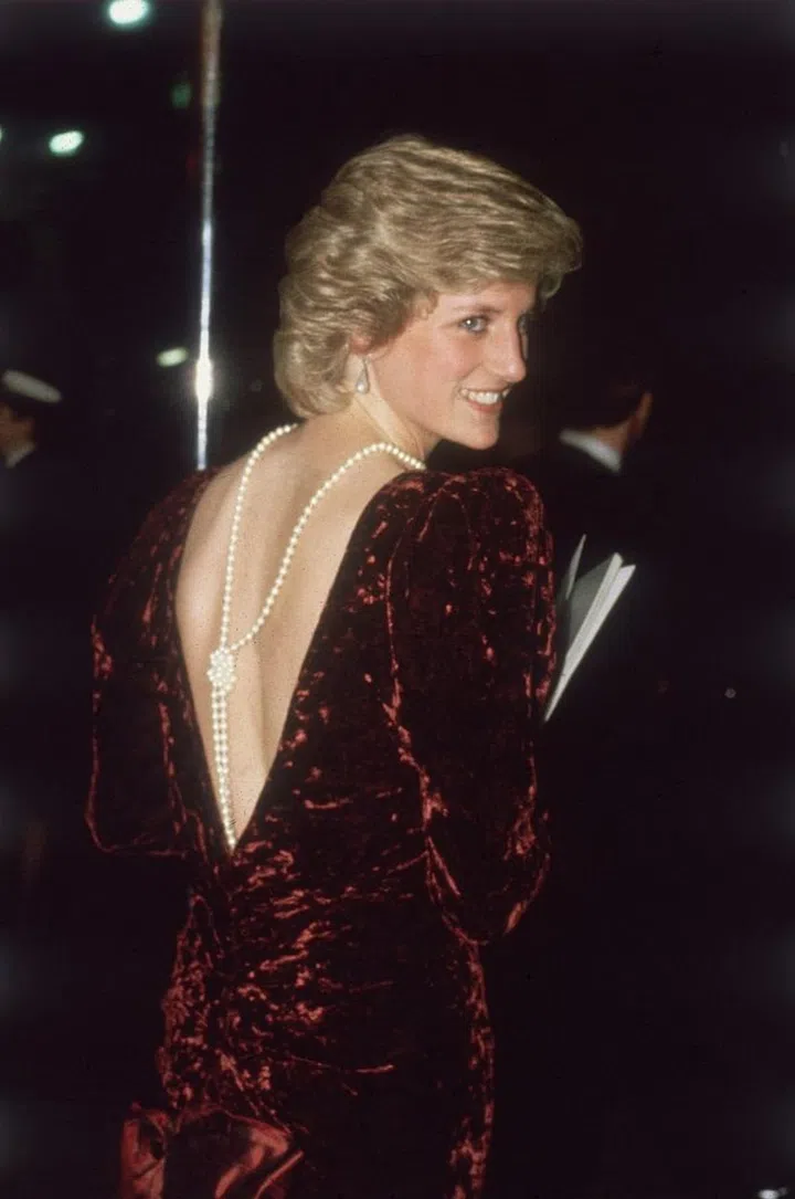 Princess Diana attends the premiere of 'Back To The Future' at The Empire Cinema, Leicester Square, London wearing a burgundy velvet evening dress designed by Catherine Walker and pearls down her back on December 3, 1985. Photo: Getty