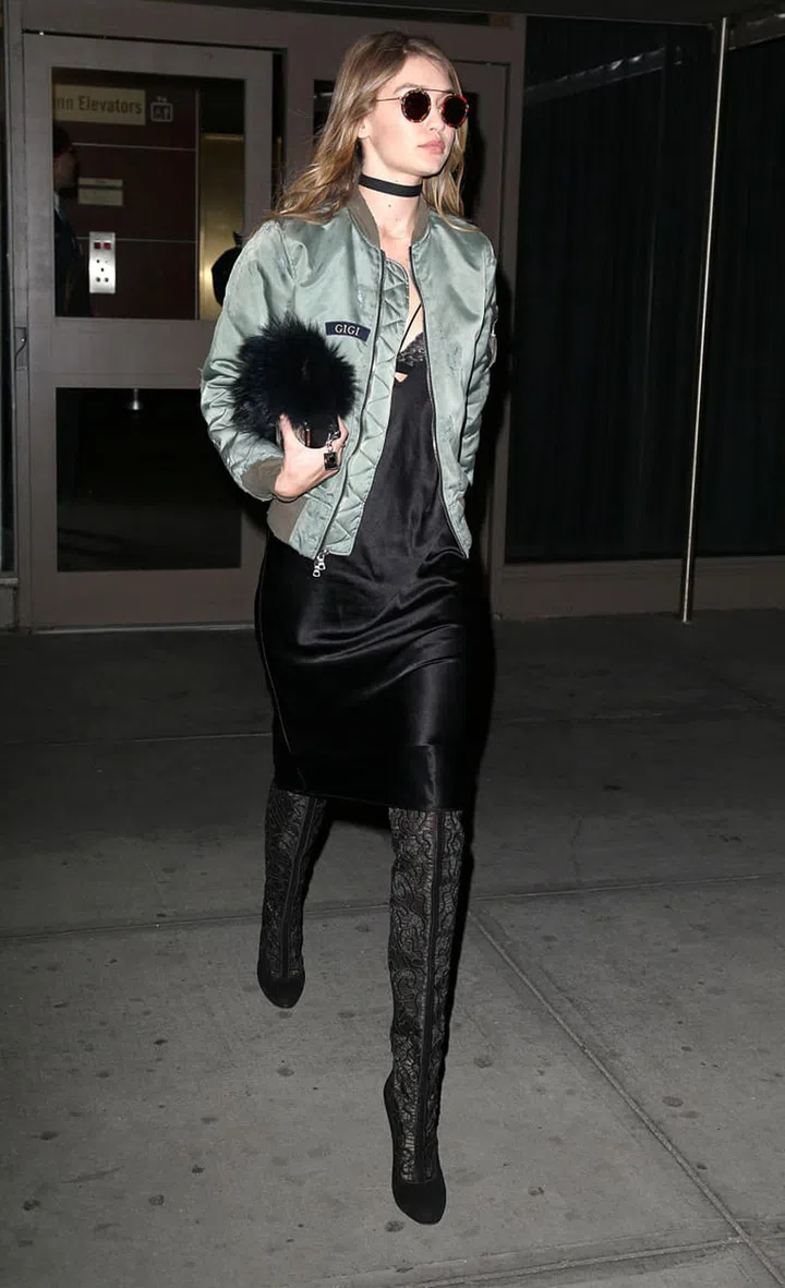 Hadid looked sultry as she stepped out in a black slip dress, custom "Gigi" green bomber, lacy thigh high boots, on-trend choker and KREWE du optic sunnies. Photo: Splash