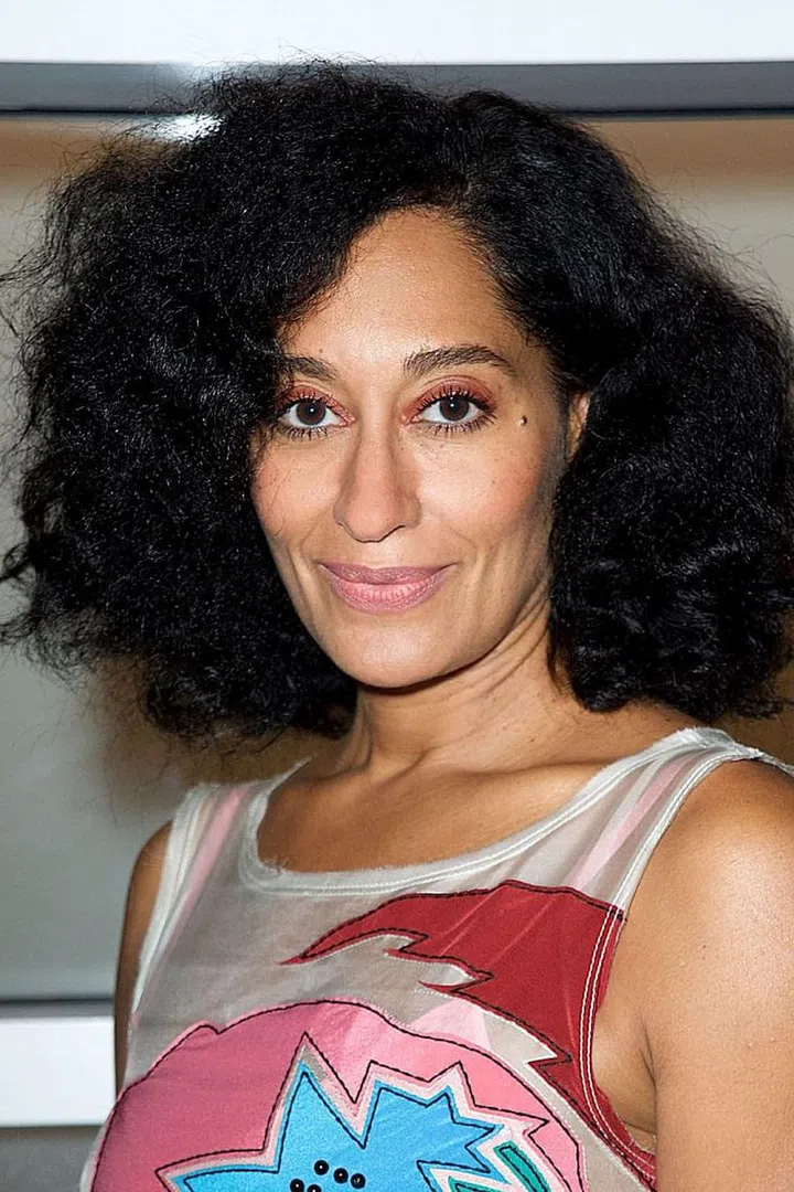 Run a brush through natural curls for soft and airy texture. Photo: Getty