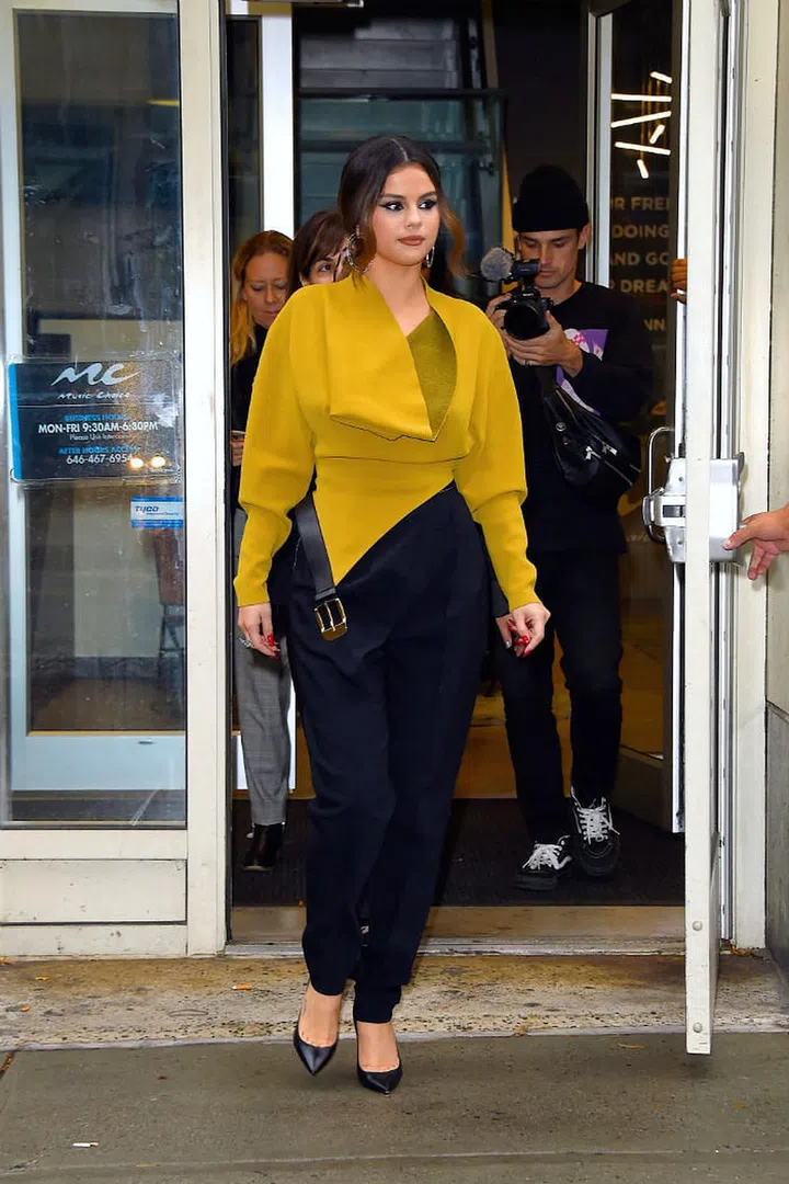Selena Gomez wears a yellow and black Proenza Schouler ensemble, Saint Laurent pointed toe pumps and silver hoop earrings at Midtown, New York City.

Photo: Getty