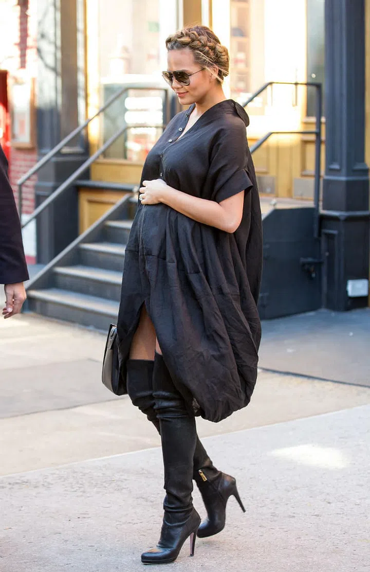 Sporting a fashionably dark getup, Chrissy matches a loose-fitting shirt dress with a pair of knee-length leather boots, which gives her a sophisticated finish. She completes the look with a pair of black aviators and her hair up in feminine milkmaid braids. Photo: Getty