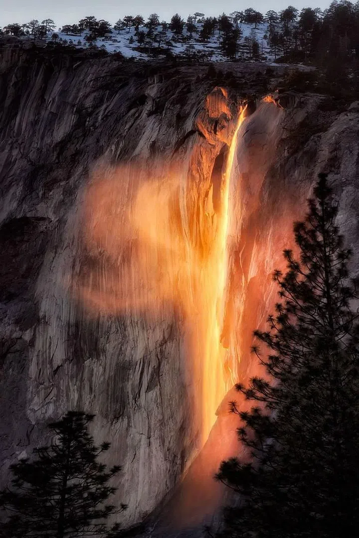 "For two weeks out of the year, the sun aligns just right with Horsetail Falls in Yosemite National Park where the waterfall glows like lava a few minutes before sunset. To get prime real estate for this shot, I set up my tripod six hours before sunset along the bank of the Merced river with over 200 other photographers. I waited for the swirling mist to rise up the waterfall, and on the second evening produced this magical image." —Nicki Frates