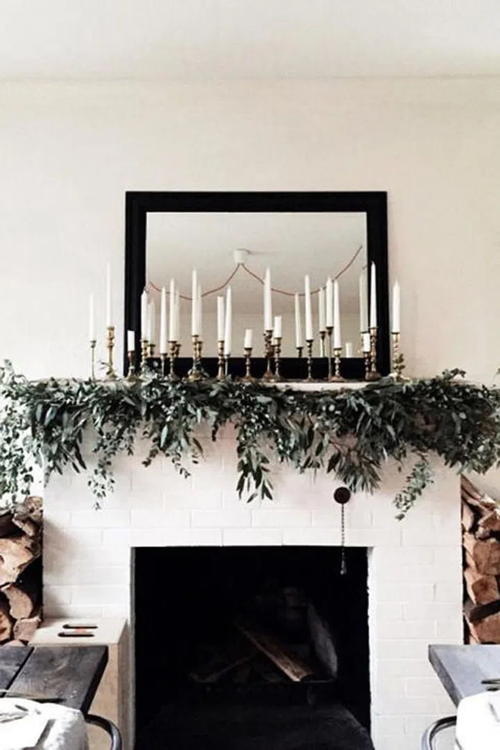 Make your mantlescape the main event with a cluster of candles and simple greenery that feels effortlessly elegant.