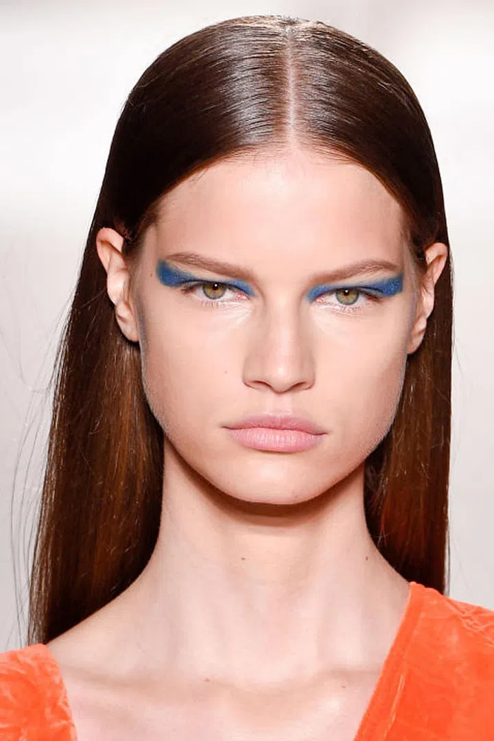 Victoria Beckham's aesthetic is a lot of things, but carefree is not one of them. Yet her spring 2017 collection showed off a more relaxed Beckham woman — the dressers were looser, the pants a little baggier. And that's the direction the beauty look went as well; while the hair was polished and sleek, the makeup took a bolder approach. Makeup artists piled on emerald green and cobalt eyeshadow (from Beckham's collection with Estée Lauder), but they did so imperfectly. The shape was more painterly than graphic, which lent a fun and energetic vibe to the entire look.