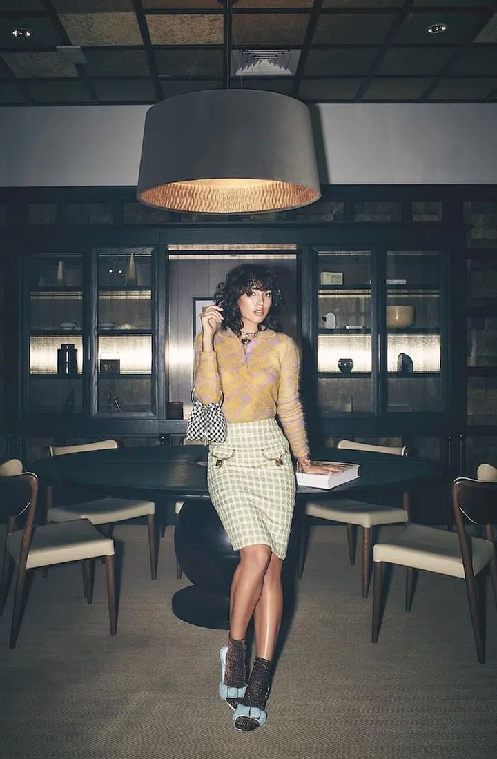 Skirt, by Moschino. Top, by Prada. Necklace, by Chanel. Bag, by Jimmy Choo. Bracelets, by Swarovski. Slides, by Coach. Socks, stylist’s own. (Photo: Veronica Tay)