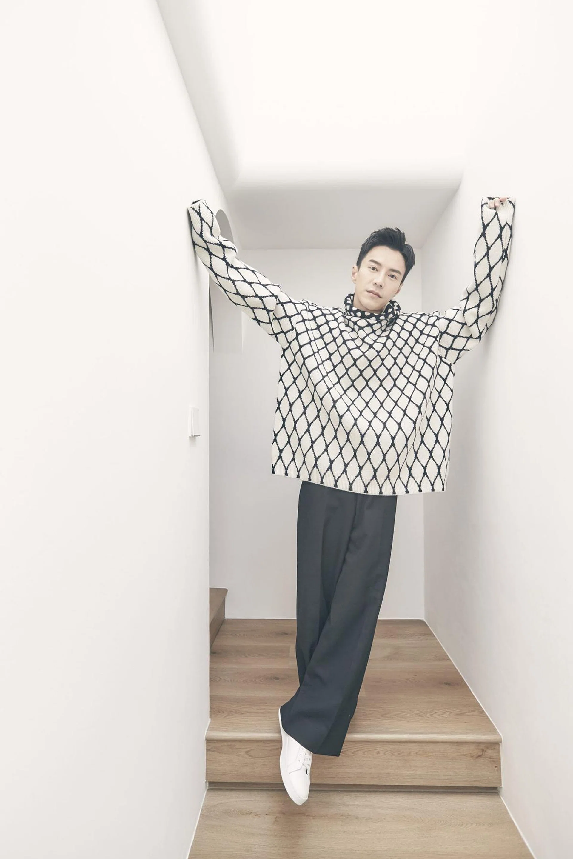 Lawrence Wong on his second-level stairwell, wearing a sweater and trousers from Valentino, and sneakers from CELINE by Hedi Slimane. Photo: Veronica Tay. 