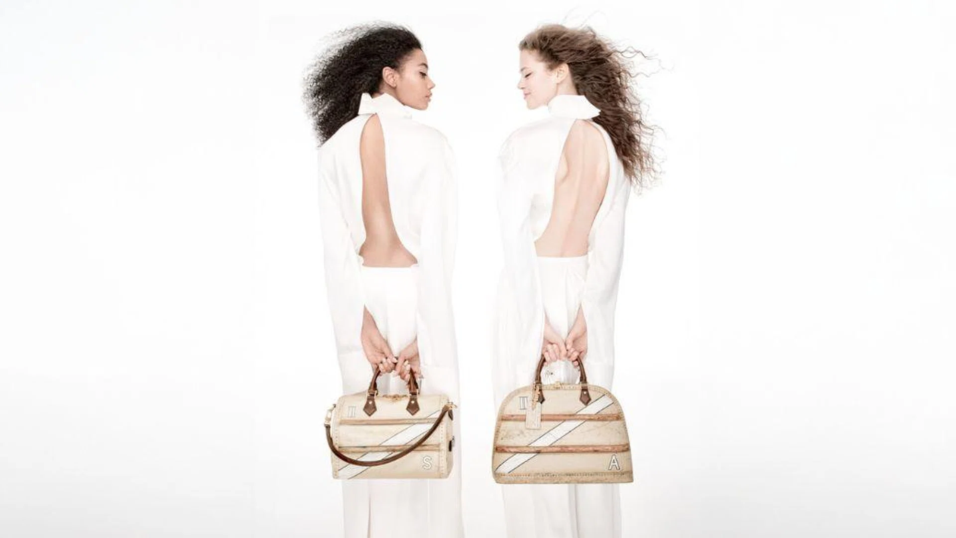 Models carrying Louis Vuitton Time Trunk Speedy and Alma bags.