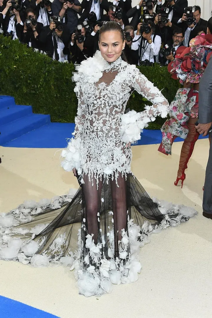 Chrissy Teigen's continues the sheer trend with this ornate black and white lace gown with floral tulle accents. The sheer black train provides a subtle peekaboo effect. Photo: Getty 