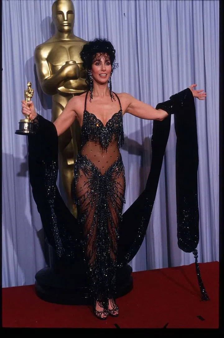 Cher took home the Oscar for Best Actress for 'Moonstruck' this year in another Bob Mackie design. Serving up yet another iconic red carpet look, she dazzled in a jewel-encrusted naked dress with a sparkling fringe bra and matching shawl. Photo: Getty  