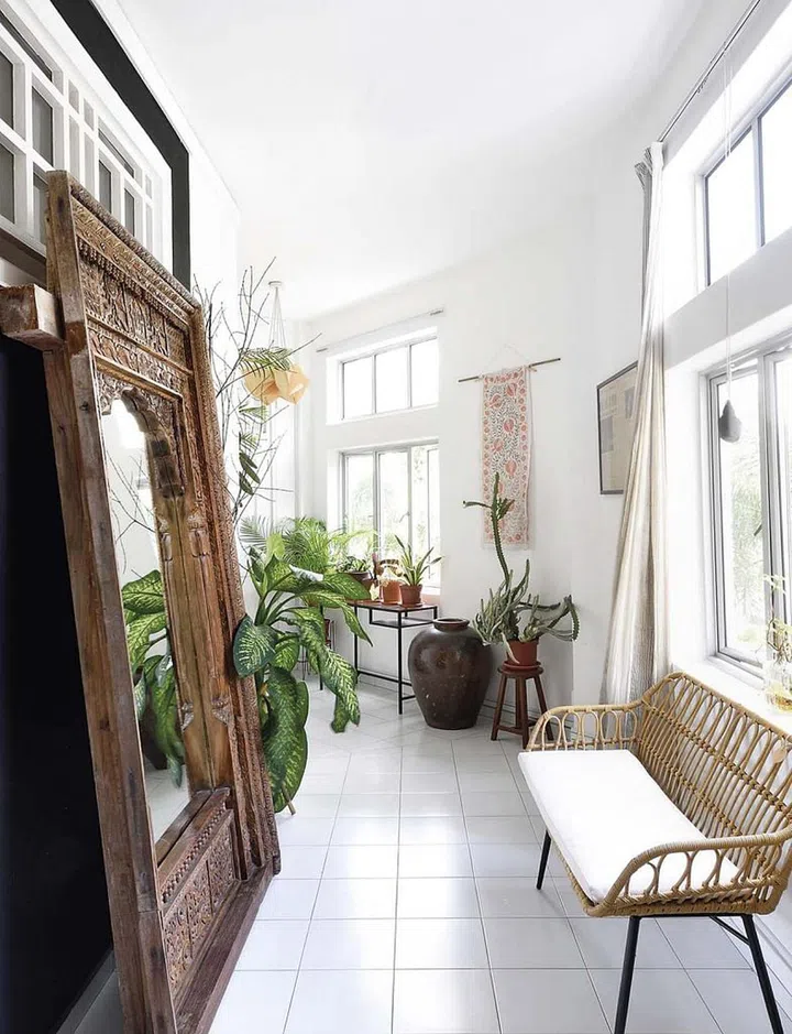 Here and there are collectibles accumulated from around the world. An antique Indian arched door, a reclaimed wood mirror, hand-embroidered Uzbekistan textile, Japanese noren, Chinese thrift store lights, and ceramic lamps from Vietnam are artfully displayed throughout the home. (Photo: Carli Teteris, courtesy of Grounded)
