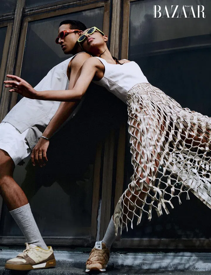 (On him) Tank top; shorts, Hermès. Sunglasses, Prada. Sneakers, Fendi. Jewellery; socks, model’s own. (On her) Tank top; skirt, Tod’s. Sunglasses, Prada. Sneakers, New Balance 574 X Miu Miu. Socks, stylist’s own
