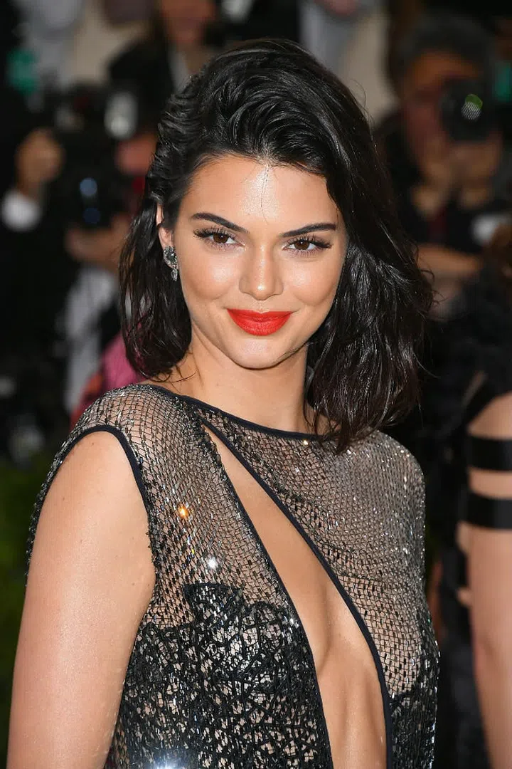 This Jenner sister took a glamorous approach to the red carpet, sporting a glowing visage with attention to her deep coral lips that brought a freshness to the look (Photo: Getty)