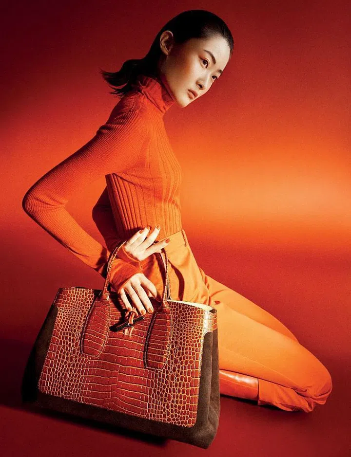 Roseau Frame Top Handle bag, $1,440; sweater, $290; trousers, $760; boot, $1,460.