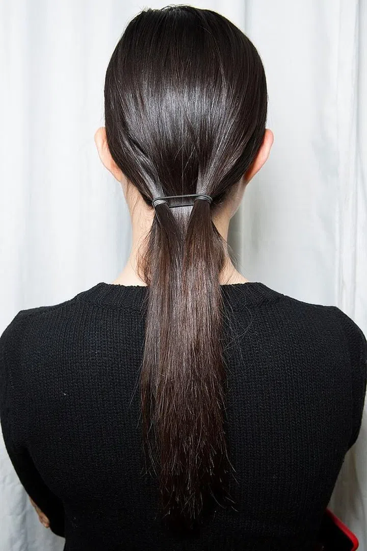 The hair at Delpozo was described as a little "futuristic." It was also a little complicated. Look closely, and you'll see that two sections of hair were tied into pigtails, with the rest of the hair falling straight behind it. Stylists then grabbed a third elastic and gathered all he hair—the two pigtails and the hair in the back—together to make one low ponytail.