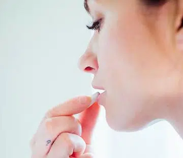 woman eating immunity-boosting supplement feature image