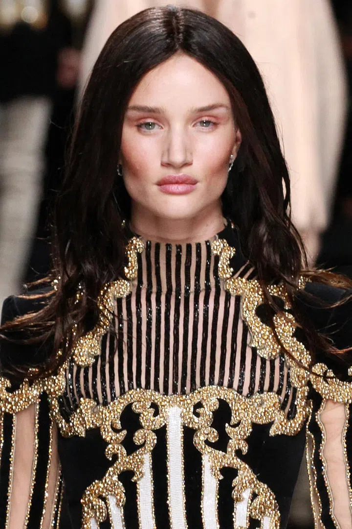 Balmain had us doing double takes after seven famous faces (among them Rosie Huntington-Whiteley, Gigi Hadid, Kendall Jenner and Alessandra Ambrosio) temporarily swapped hair colors thanks to Sam McKnight's expert lace wig styling. "Olivier wanted to create a surprise today, but we've still got natural, sexy, easy, cool girl Balmain hair," explained McKnight, who used a curling iron and lots of serum to create believably shiny and bouncy new 'dos. Over in makeup, Tom Pecheux stuck to the script of past seasons (if it ain't broke...), contouring cheekbones to Kardashian levels, applying sheer nude cream to lips and eyelids and highlighting the inner corners of the eyes with shimmery gold lipstick.