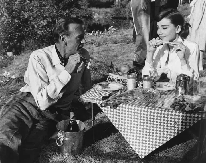 Gary Cooper and Audrey Hepburn share a picnic on the set of the film Love in the Afternoon. Photo: Getty