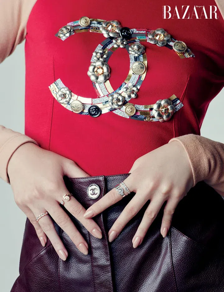 (Right hand) Beige gold and diamond Coco Crush mini ring; Beige gold and diamond Extrait de N°5 ring, Chanel. (Left hand) White gold and diamond Eternal N°5 ring; white gold and diamond Coco Crush mini ring, Chanel. Top; trousers, Chanel.