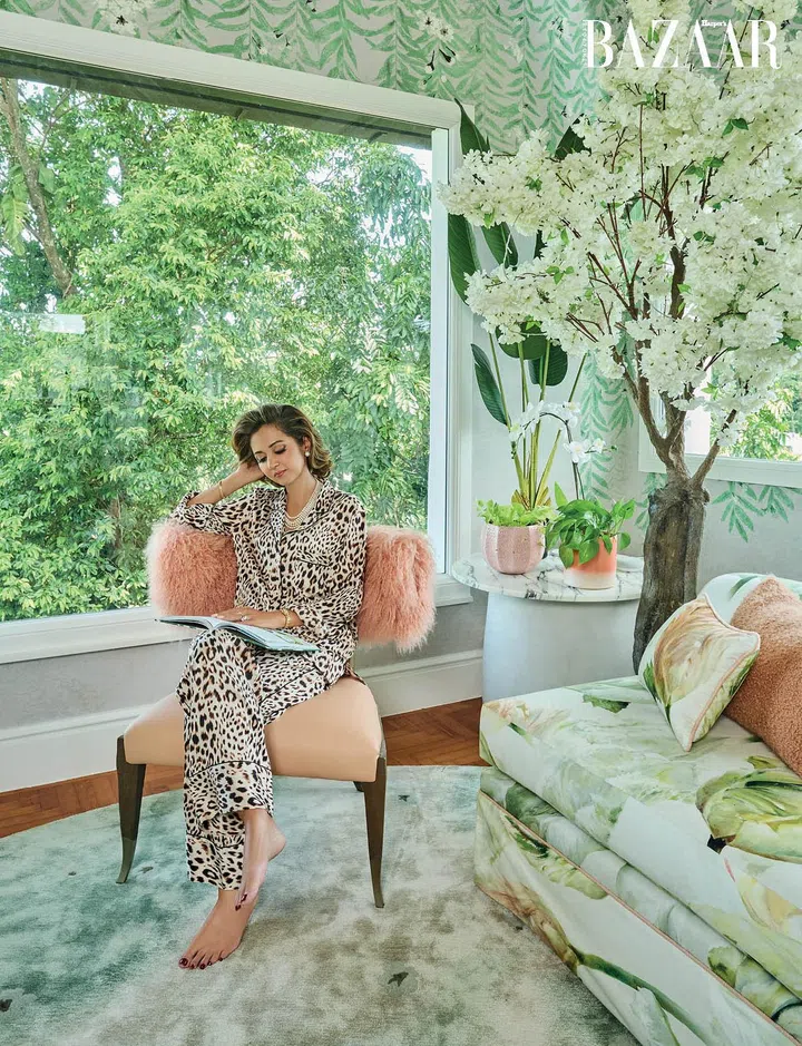 Lounging in the sitting area of her bedroom on a blush-hued chair, Hunt wears her own Victoria’s Secret pajamas.