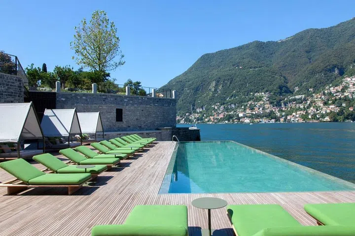 At the center of the hotel's gardens is a 60-foot-long infinity pool placed lengthwise in front of Lake Como and surrounded by a sundeck where guests can relax and enjoy food and drinks. Next to the pool is a small beach that gives guests direct access to the lake. Designed by famed Milan-based designer Patricia Urquiola, Il Sereno opened this past summer as the first luxury contemporary hotel in the area. "The freshwater pool suspended over the lake is without a doubt one of our show-stopping features," says managing director Samy Ghachem. "As the colors of the sky begin to change in the early evening, so does the color of the water, which creates this magical effect that makes it look like it really does flow right into Lake Como. The pool's large sundeck is perfect for spending a leisurely afternoon under the Italian sun." 