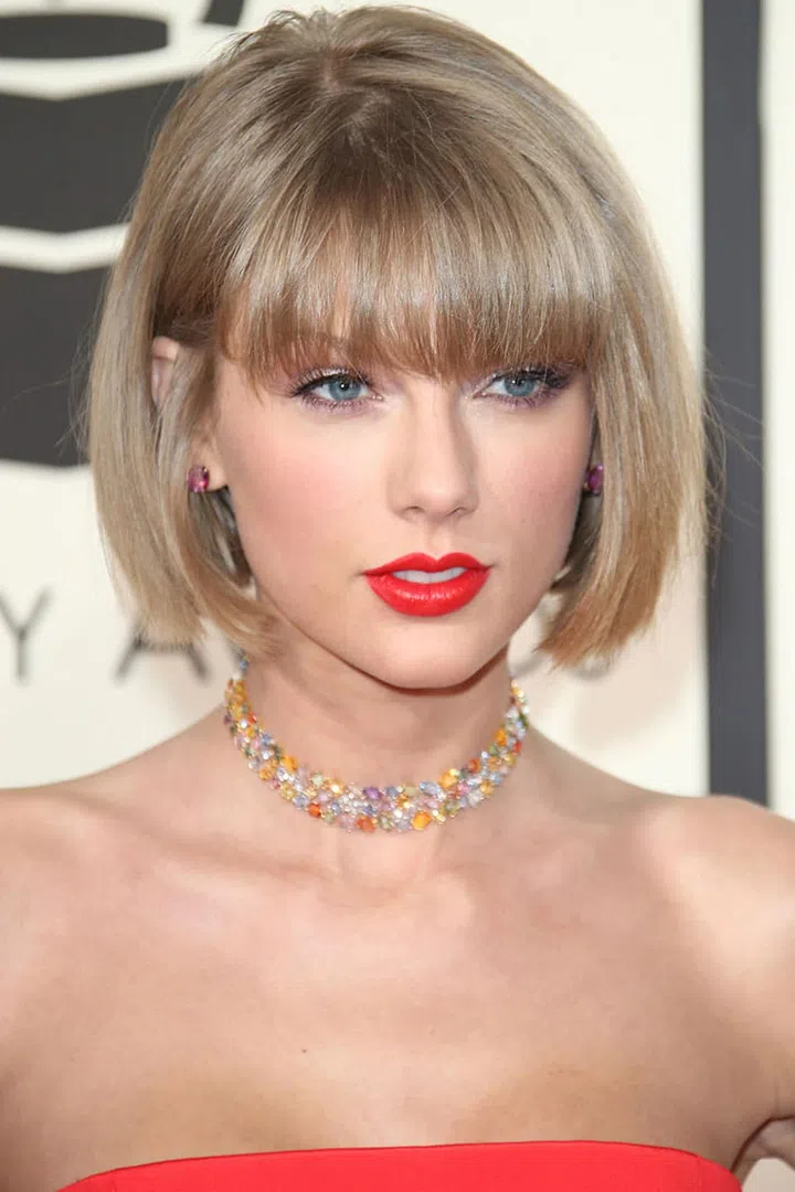 Swift's signature red lip got an edgy upgrade this year—veering into electric peach territory.
