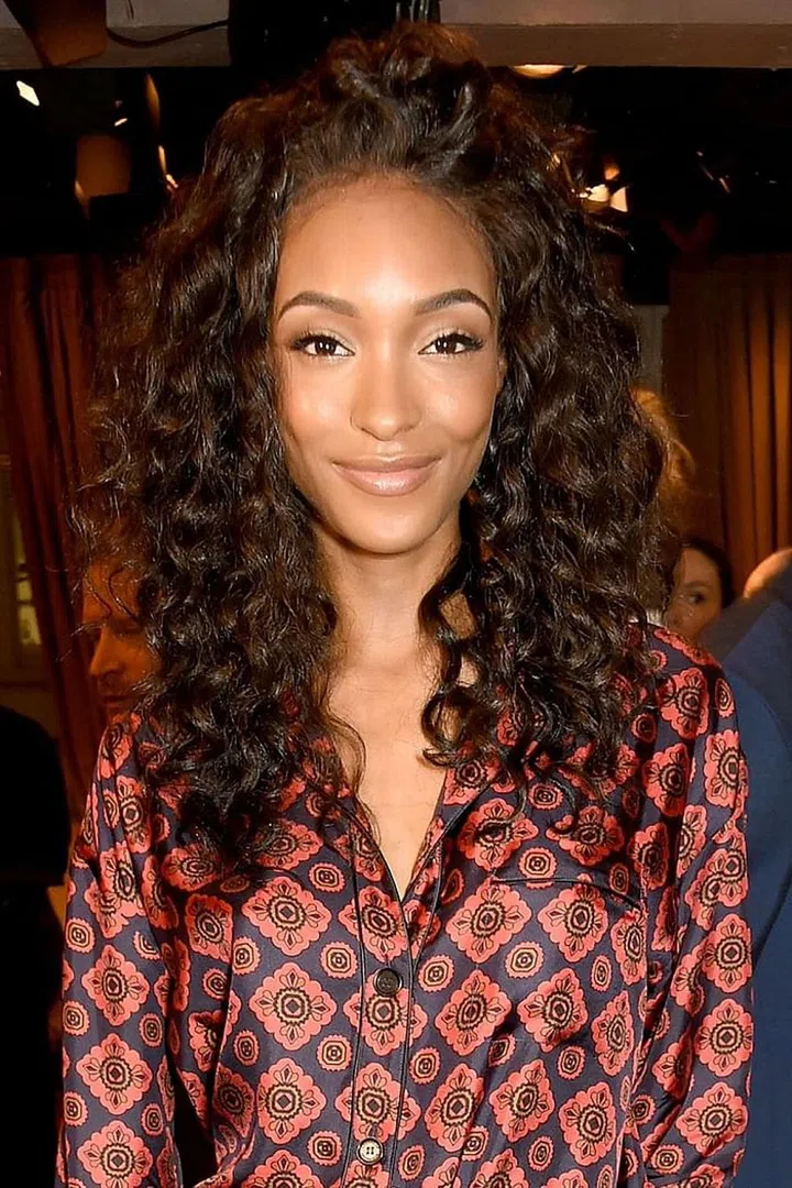 Flipping your curls over to one side, like model Jourdan Dunn, will give your hair a casual, touchable vibe. Keep flipping the part side-to-side to pump up the volume in an instant. 